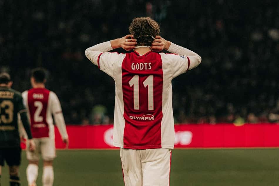 Mika Godts com camisa do Ajax com as mãos no ouvido