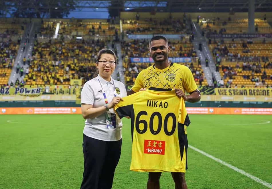 Nikão segurando camisa número 600 em homenagem aos 600 jogos na carreira