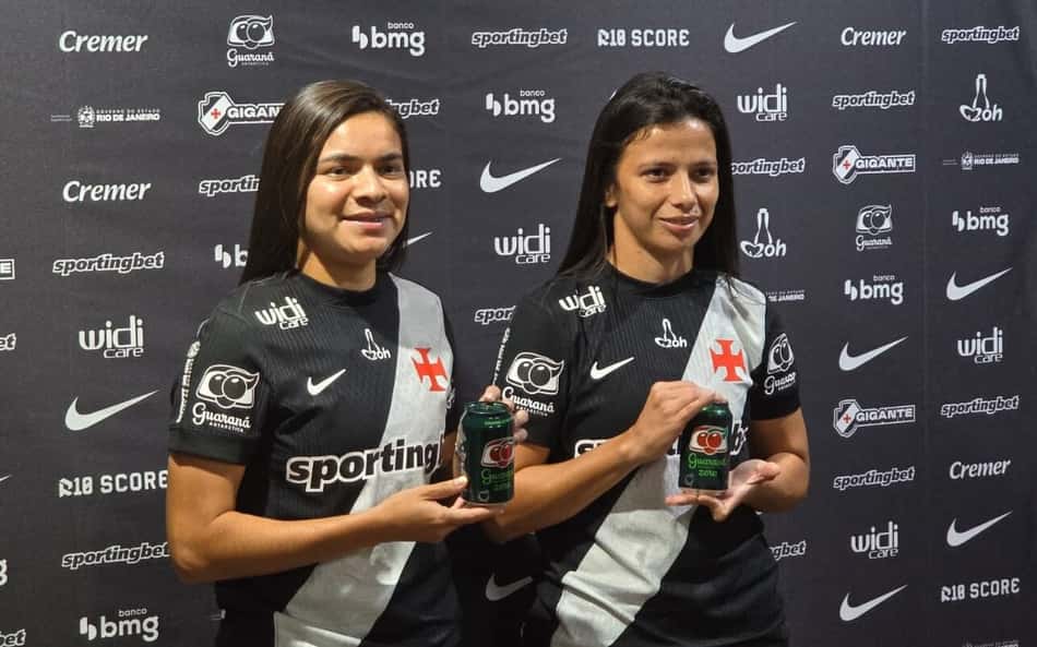 Duas jogadoras posam com camisa do Vasco e segurando uma lata de guaraná