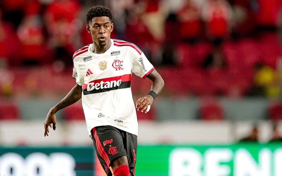Vitão com a camisa branca do Flamengo em movimento após realizar um passe