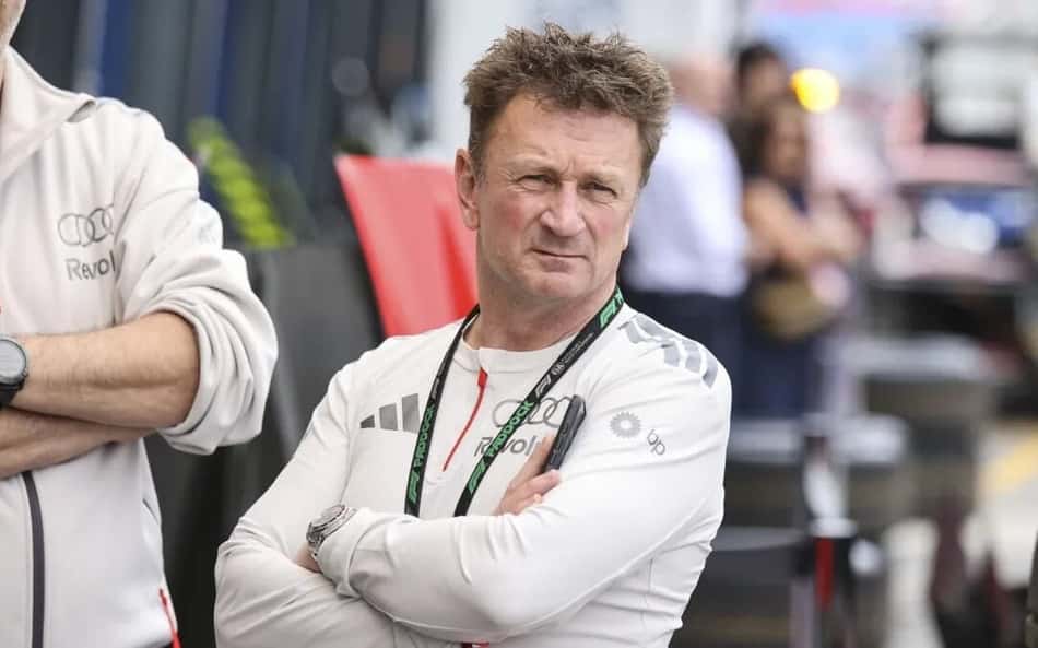 Allan McNish, chefe da Audi na Fórmula 1, olha para o lado de braços cruzados