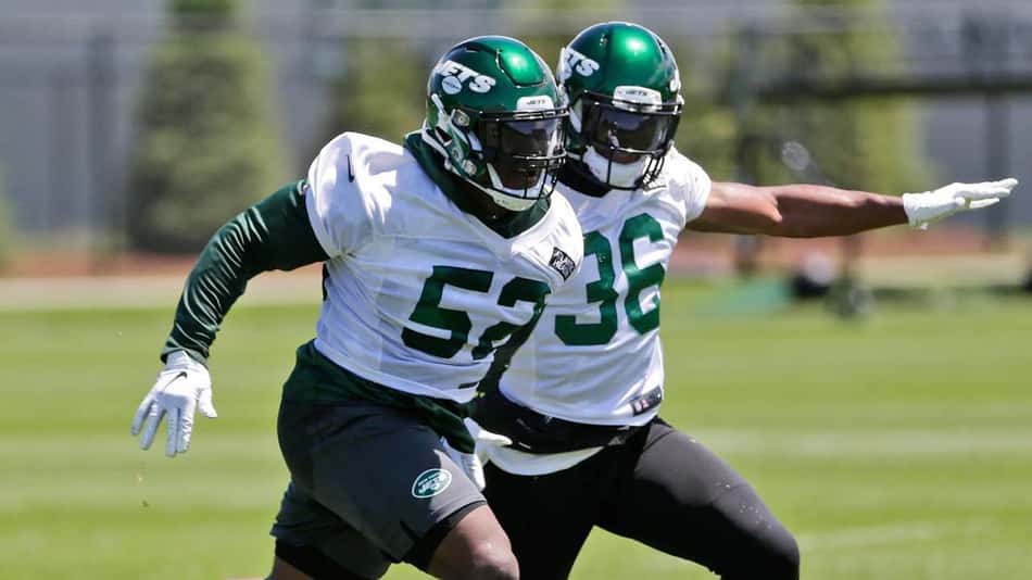Com a camisa 52, Anthony Wint, então leftbacker do New York Jets, corre com a bola durante treino da equipe