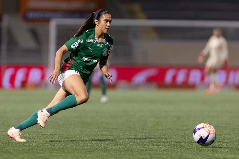 Antonia correndo com a bola à sua frente ao seu lado na imagem