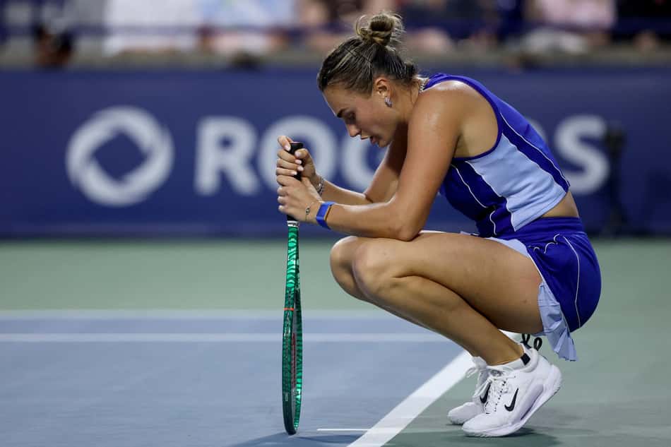 Desapontada, Aryna Sabalenka vira a raquete de ponta-cabeça sobre a quadra após ser eliminada do WTA 1000 de Toronto