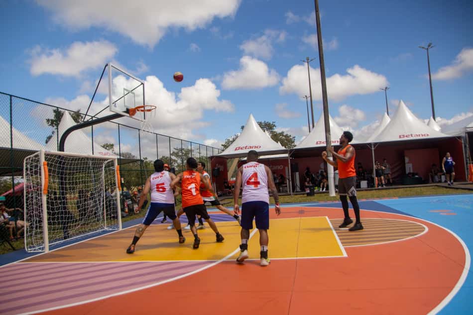 Grupo de pessoas jogando basquete em uma quadra colorida