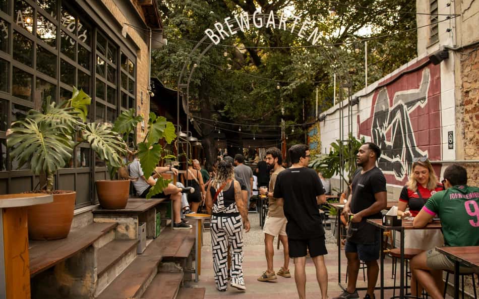 imagem de um bar arborizado com pessoas no centro da imagem
