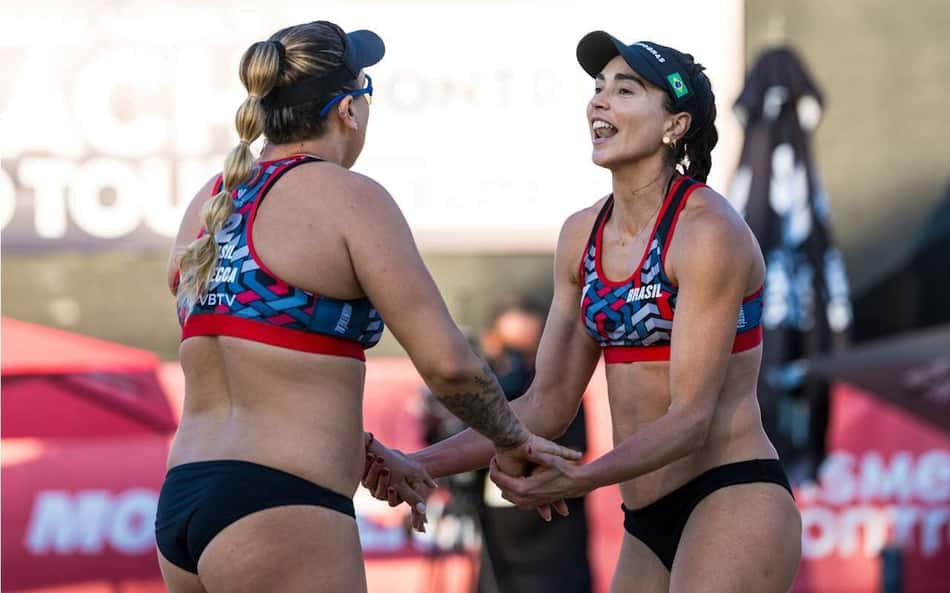 Rebecca, de costas, cumprimenta Carol Solberg, de frente, após a dupla marcar ponto em jogo da etapa de Montreal do Circuito Mundial de vôlei de praia