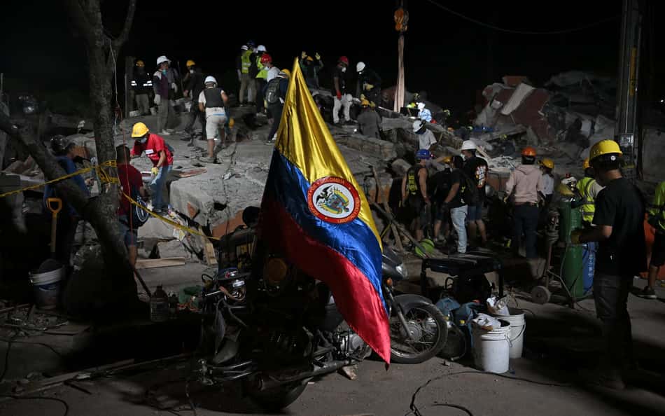 Bandeira da Colômbia sobre escombros provocados por terremoto