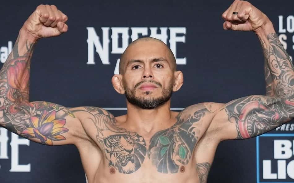 Diego Ferreira ergue os punhos cerrados e mostra os dois bíceps durante pesagem do UFC Noche