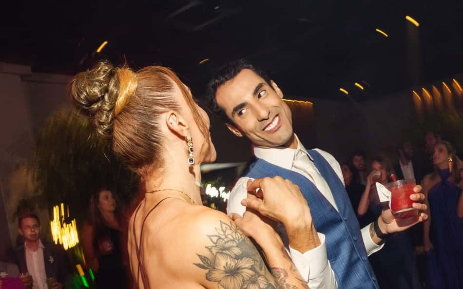 Douglas Souza ri para Tifanny, de costas, na festa de casamento do jogador