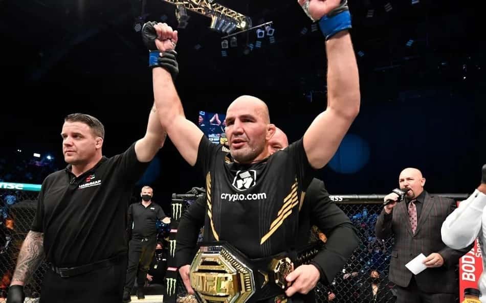 Glover Teixeira levanta os braços com o cinturão do UFC