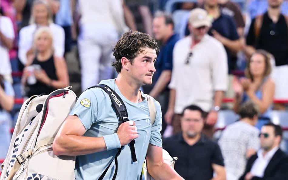 João Fonseca deixa a quadra central do Estádio IGA, segurando sua mochila nas costas com a mão direita, após eliminação no Masters 1000 de Montreal