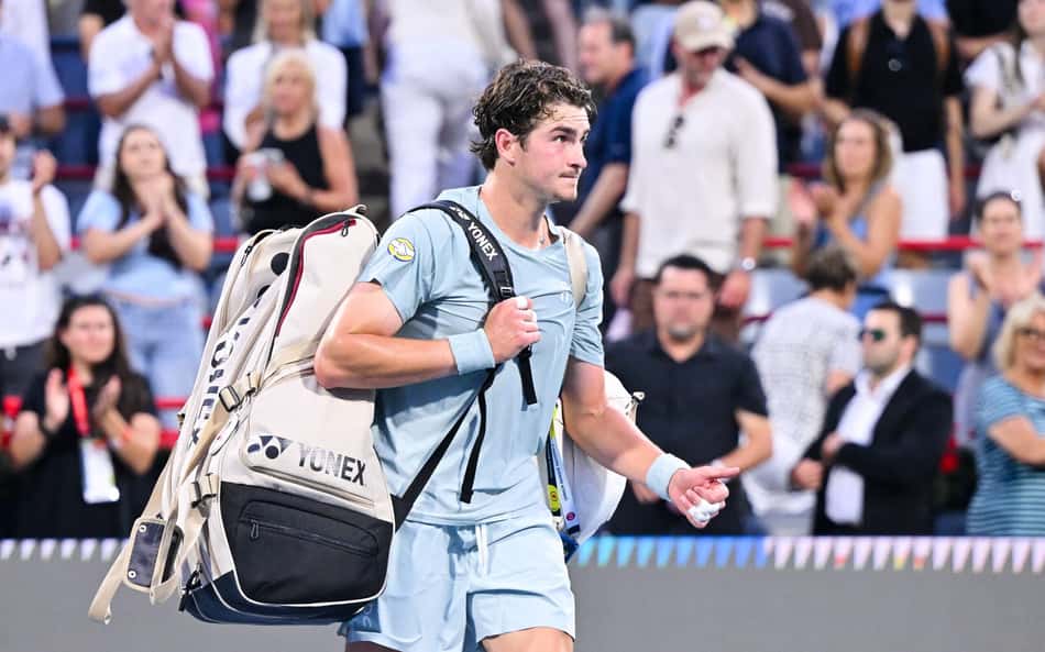 João Fonseca deixa a quadra central do Estádio IGA, segurando sua mochila nas costas com a mão direita, após eliminação no Masters 1000 de Montreal