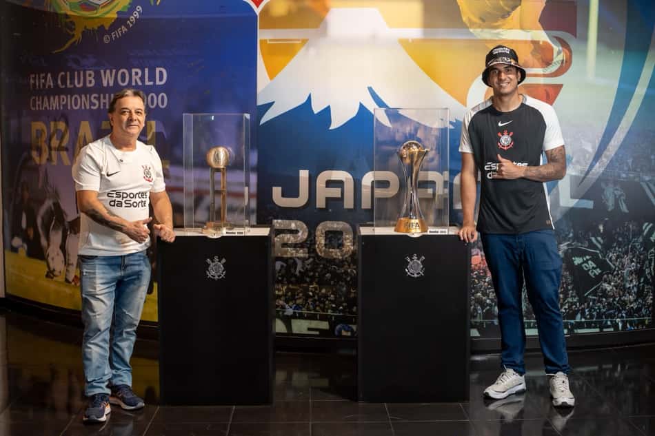Pai e filho posam ao lado dos troféus do Corinthians