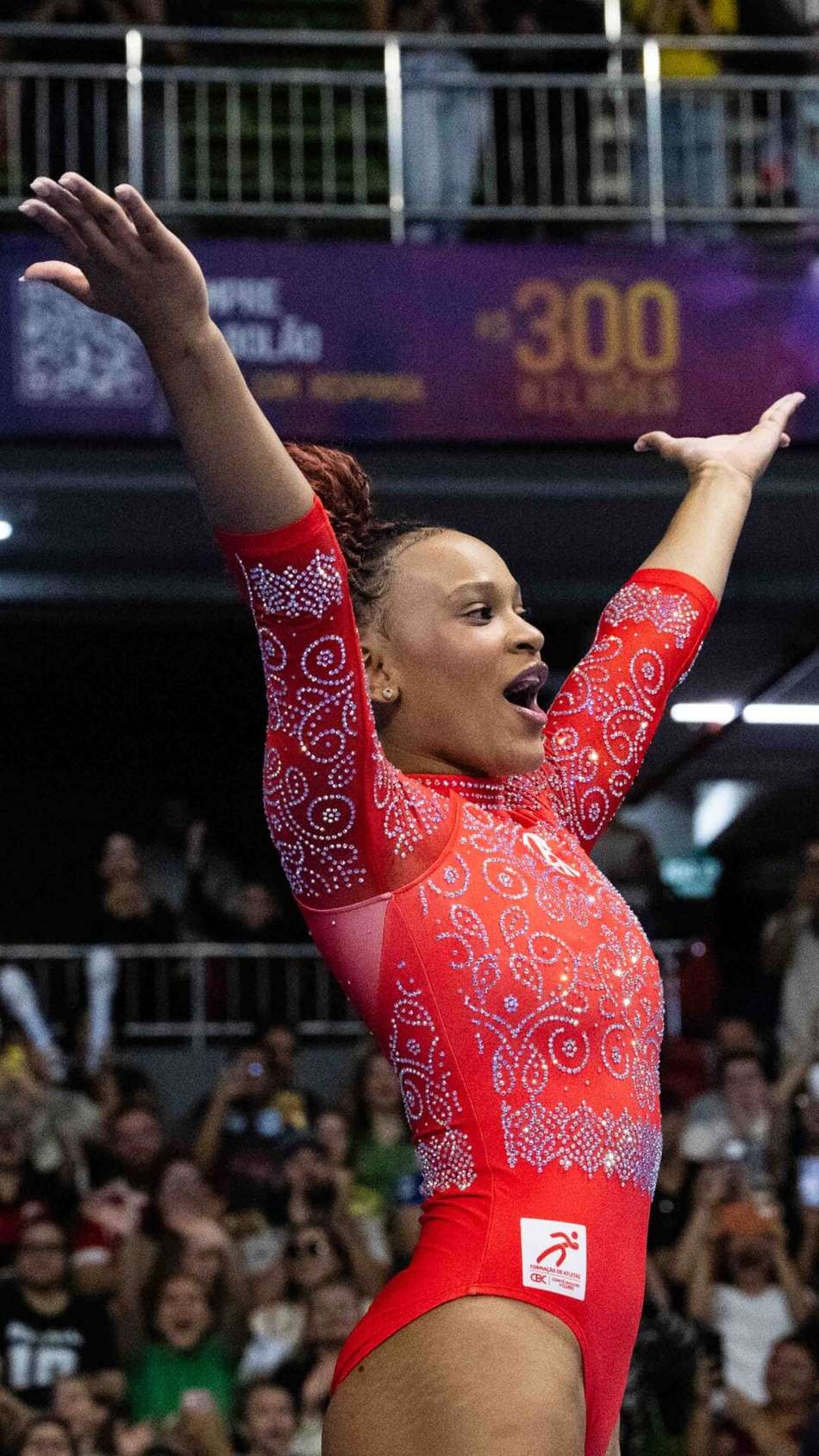 Rebeca Andrade com os braços para o alto e boca aberta após executar salto no Brasileiro de ginástica artística 2026