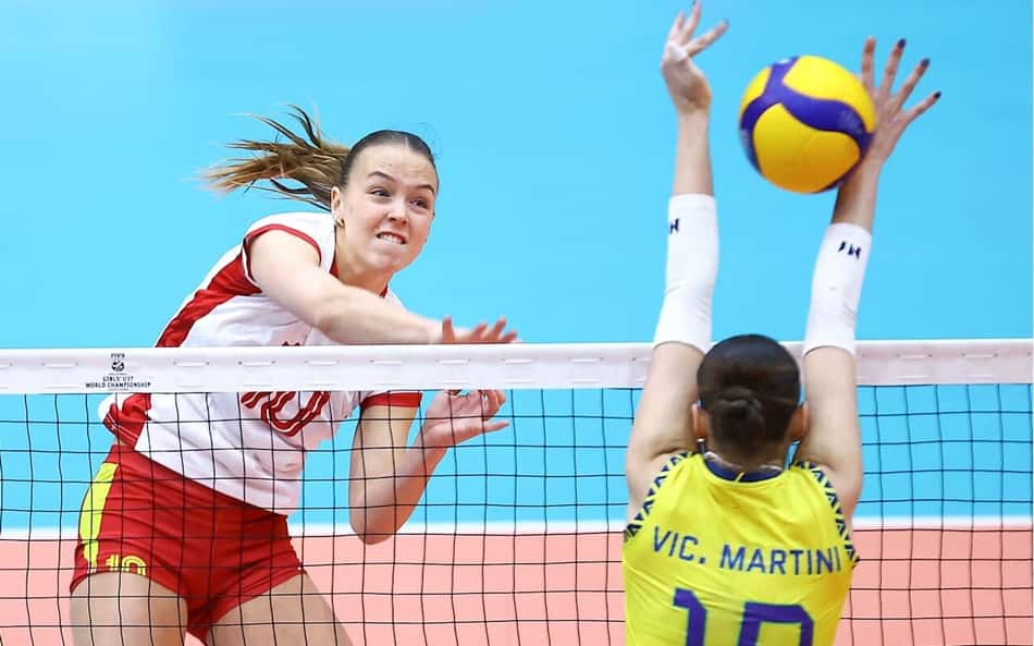 Jogadora da Espanha ataca contra o bloqueio de Vic Martini, ponteira da Seleção Brasileira feminina de vôlei sub-17, em jogo válido pelo Campeonato Mundial da categoria