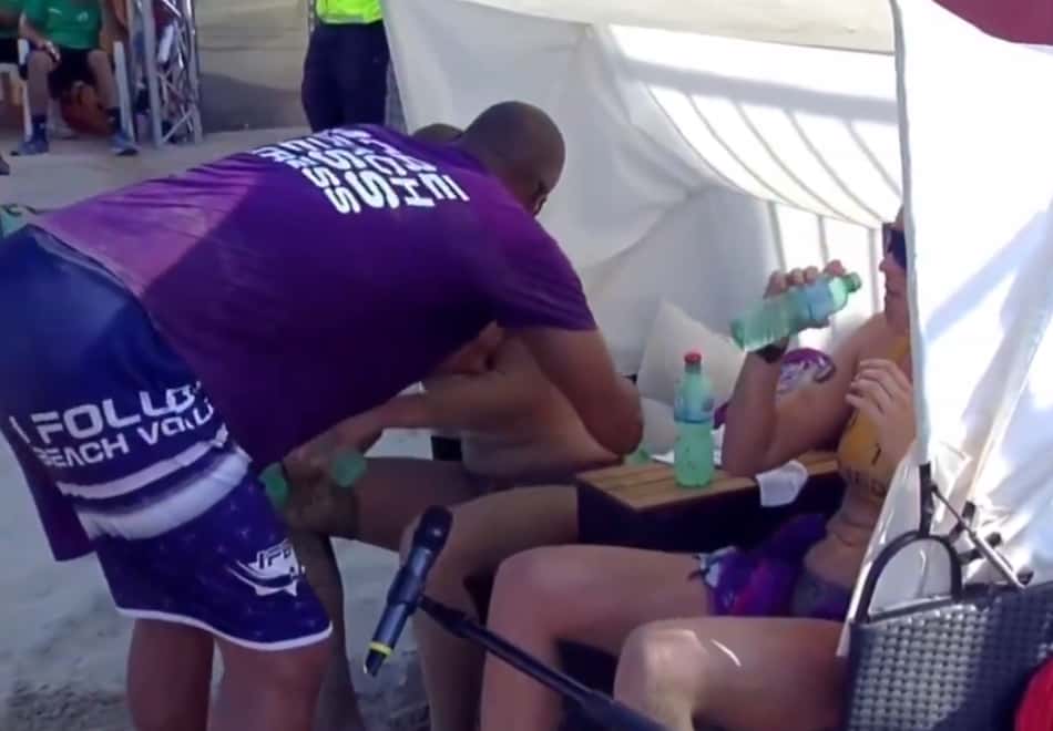 Técnico brasileiro James Martins agarra atletas pelo braço em campeonato de vôlei de praia