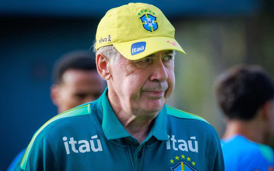 Carlo Ancelotti faz careta de boné amarelo e de agasalho da Seleção Brasileira