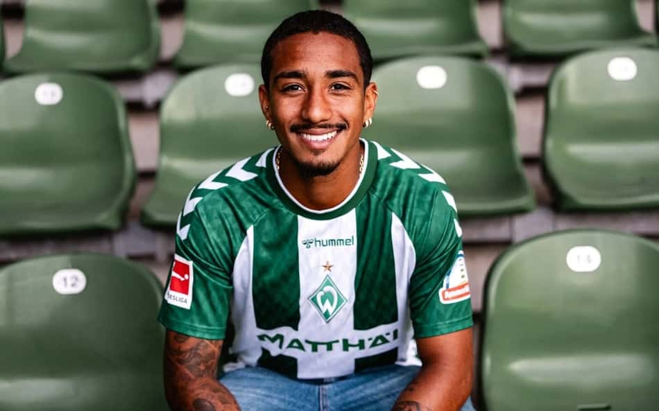 Arthur sentado na arquibancada com a camisa do Werder Bremen