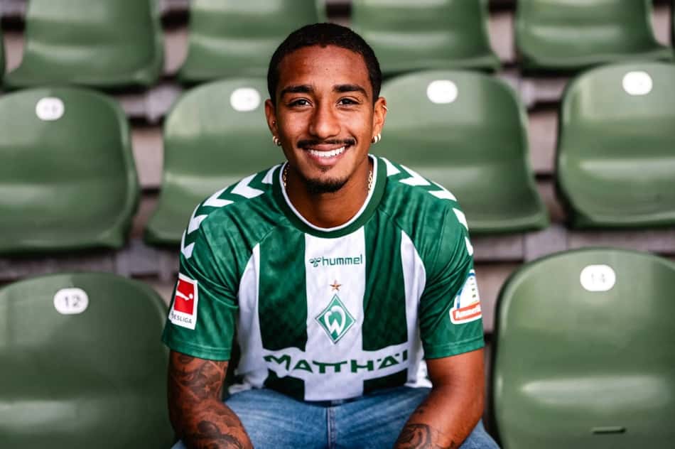 Arthur sentado na arquibancada com a camisa do Werder Bremen