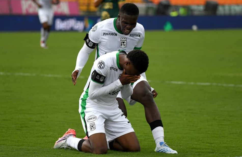 O meio-campista do Atlético Nacional, camisa 33, Hugo Benítez (embaixo), comemora após marcar um gol durante um amistoso entre o Atlético Nacional da Colômbia e a Chapecoense do Brasil, às vésperas do décimo aniversário do acidente, no Estádio Atanasio Girardot, em Medellín, Colômbia, em 26 de setembro de 2026.
