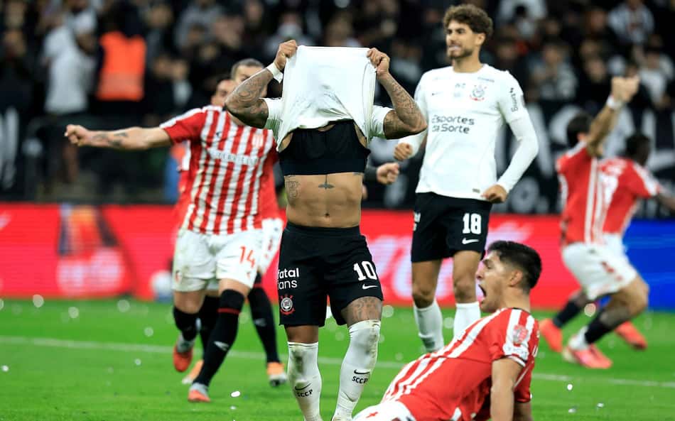 Memphis com a camisa no rosto rodeado de jogadores do Estudiantes comemorando a classificação sobre o Corinthians