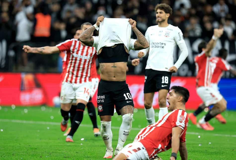 Memphis com a camisa no rosto rodeado de jogadores do Estudiantes comemorando a classificação sobre o Corinthians