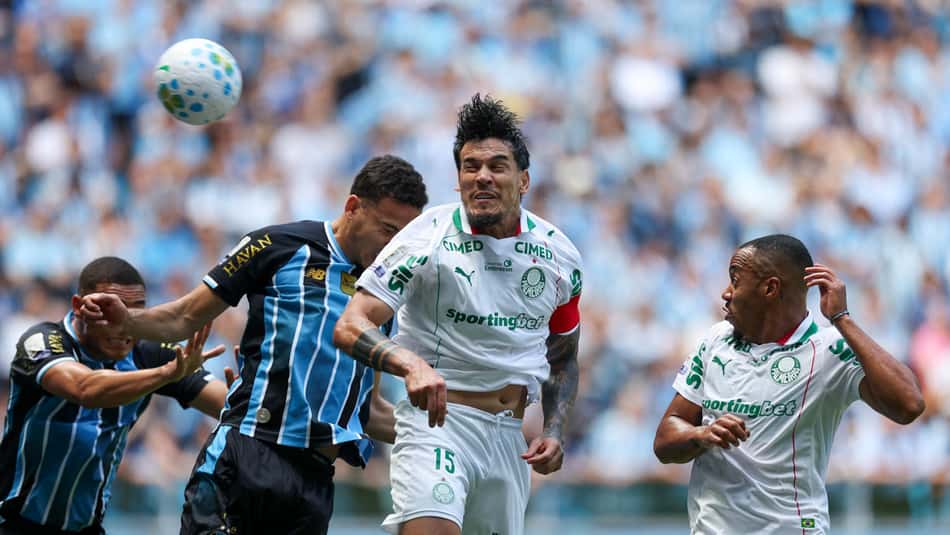 Gustavo Gómez e Marlon Freintas, do Palmeiras, disputam a bola com jogadores do Grêmio