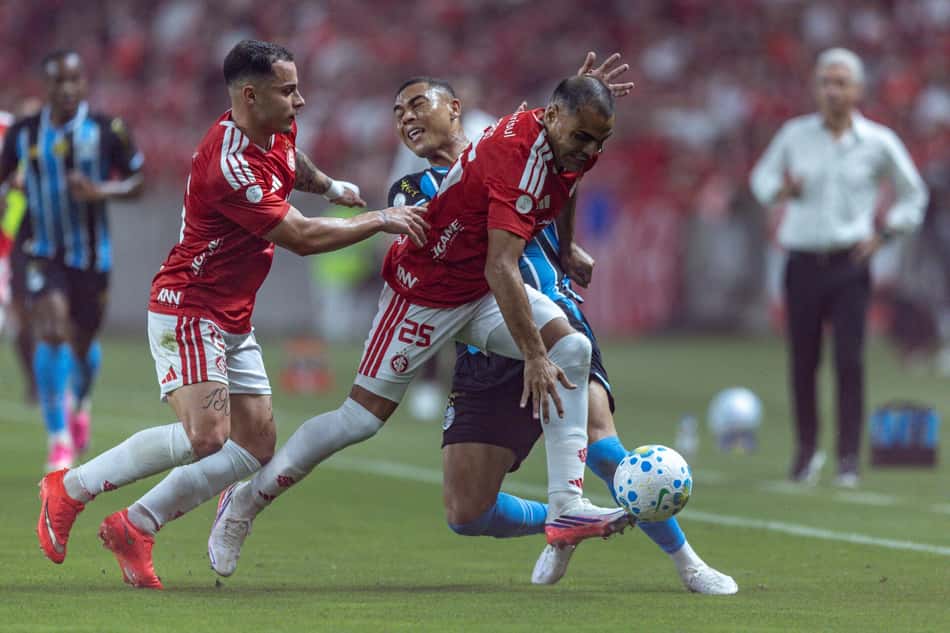 Jogadores de Grêmio e Internacional disputando bola 