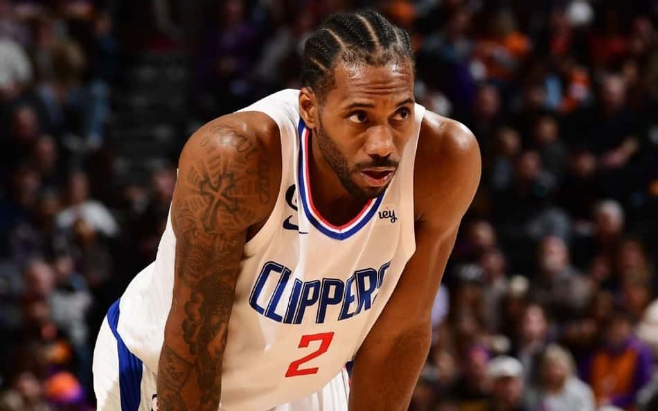 Kawhi Leonard inclina o corpo e apoia as mãos nos joelhos durante partida do Los Angeles Clippers