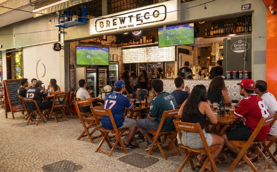Pessoas sentadas assistindo tv no Brewteco