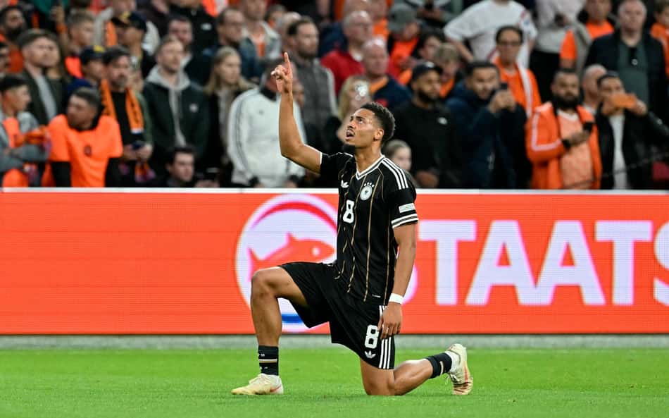 Nmaecha ajoelhado apontando para cima em jogo da Alemanha