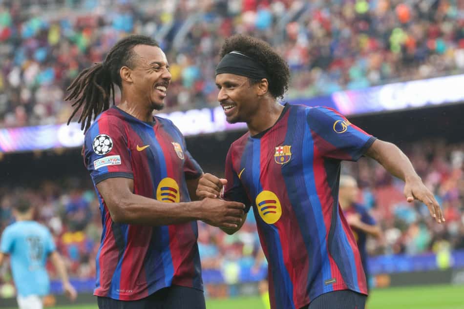 O atacante alemão do Barcelona, número 14, Karim Adeyemi (à direita), comemora o segundo gol de sua equipe com o companheiro de time, o zagueiro francês do Barcelona, número 23, Jules Koundé, durante a partida da primeira rodada da Liga dos Campeões da UEFA entre FC Barcelona e Feyenoord, no estádio Camp Nou, em Barcelona, em 9 de setembro de 2026.