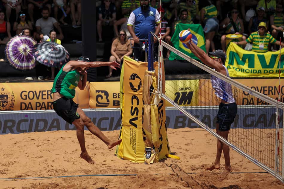 André Stein realiza movimento de ataque contra o bloqueio em jogo do Sul-Americano de vôlei de praia