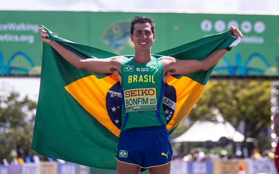 Caio Bonfim com a bandeira do Brasil, comemora medalha no Mundial de Marcha Atlética