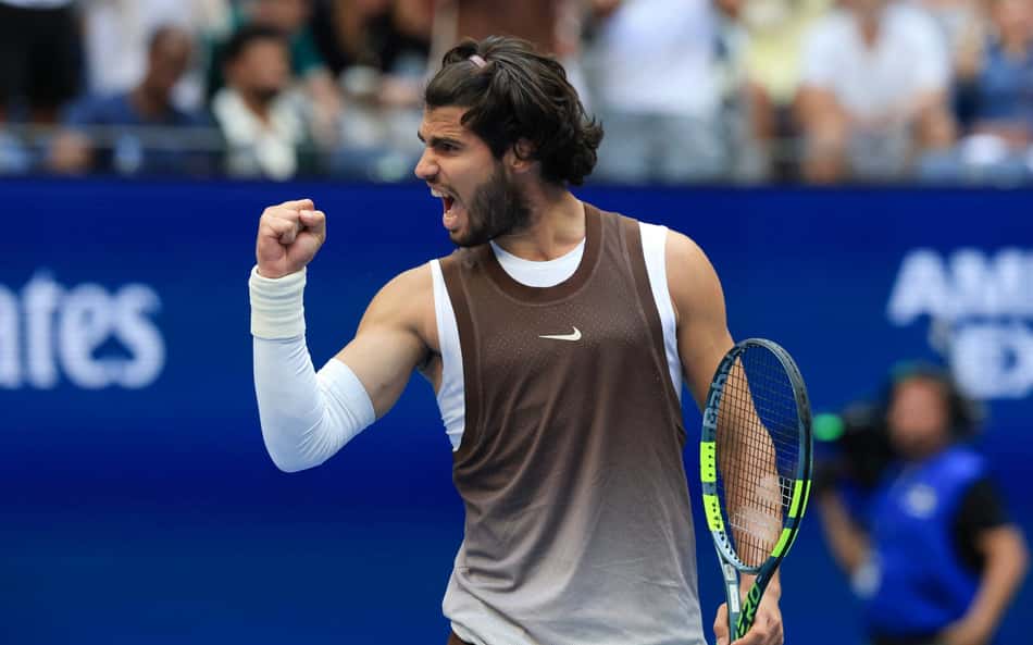 Alcaraz ergue o punho direito e segura a raquete com a mão esquerda enquanto comemora ponto no US Open