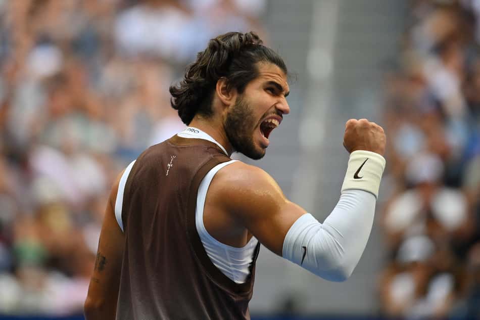 Carlos Alcaraz ergue o punho direito em comemoração de ponto durante jogo do US Open