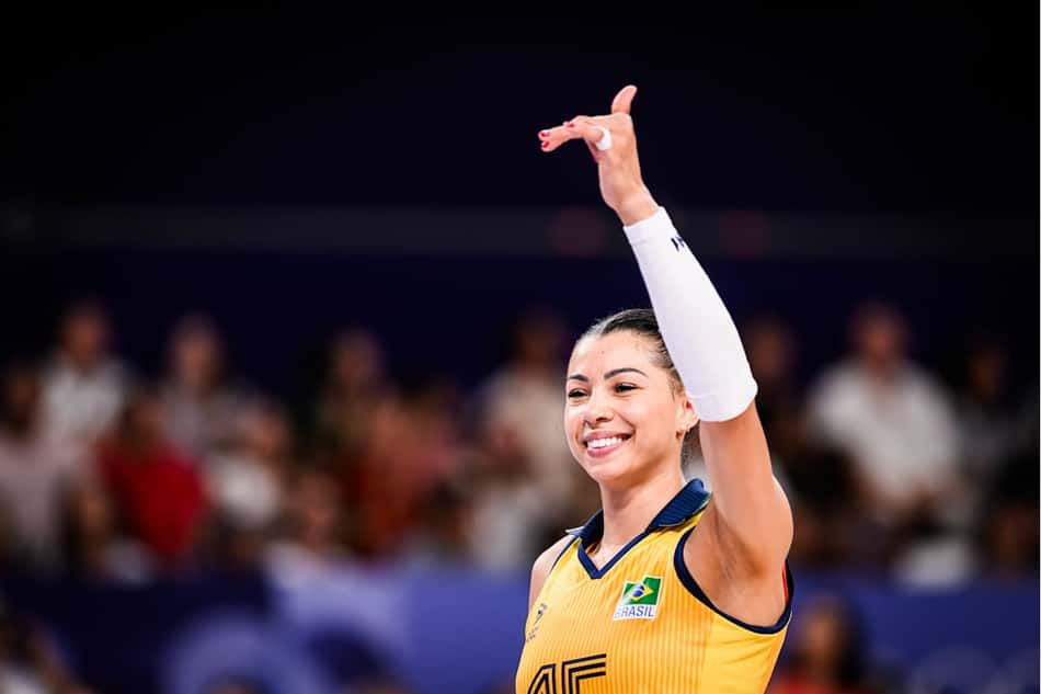 Carolana ergue o braço esquerdo e faz o sinal de "hangloose" durante jogo da Seleção Brasileira feminina de vôlei nos Jogos Olímpicos de Paris 2024