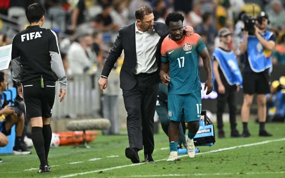 O australiano Nestory Irankunda (à direita) é parabenizado pelo técnico da Austrália, Tony Popovic, após marcar um gol durante o amistoso internacional de futebol entre Austrália e Brasil, no Queensland Country Bank Stadium, em Townsville, em 25 de setembro de 2026