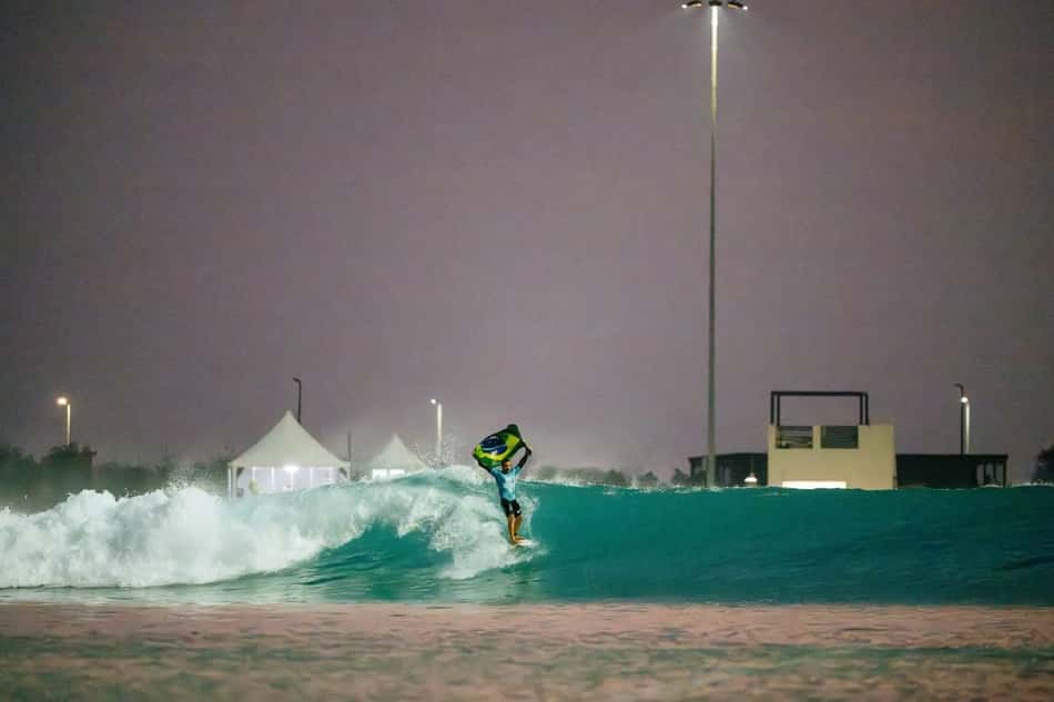Campeão da etapa de Abu Dhabi da WSL em 2025, Ítalo Ferreira surfa segurando a bamdeira do Brasil