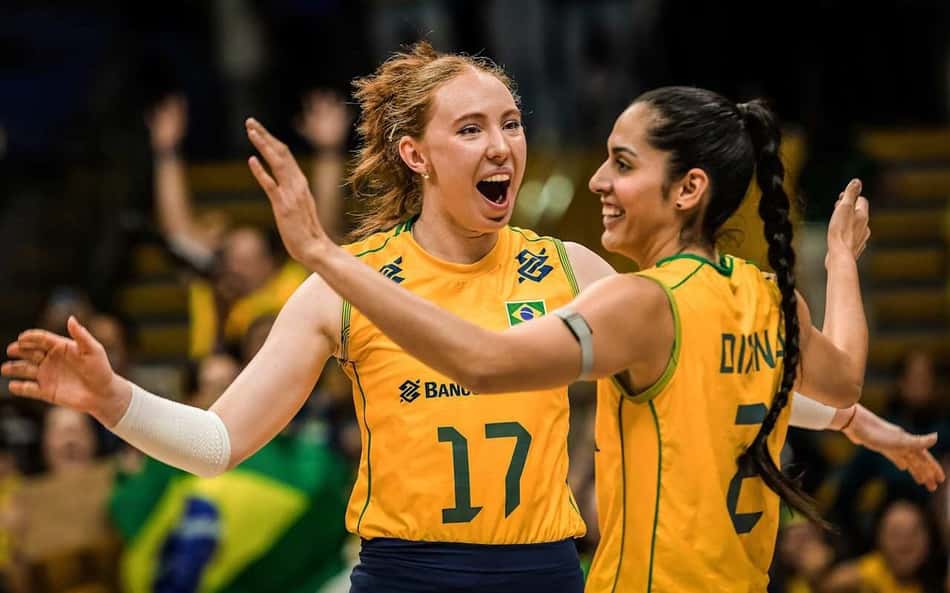 Julia Bergmann, de boca aberta, comemora ponto marcado pela Seleção Brasileira feminina de vôlei com Diana, que sorri