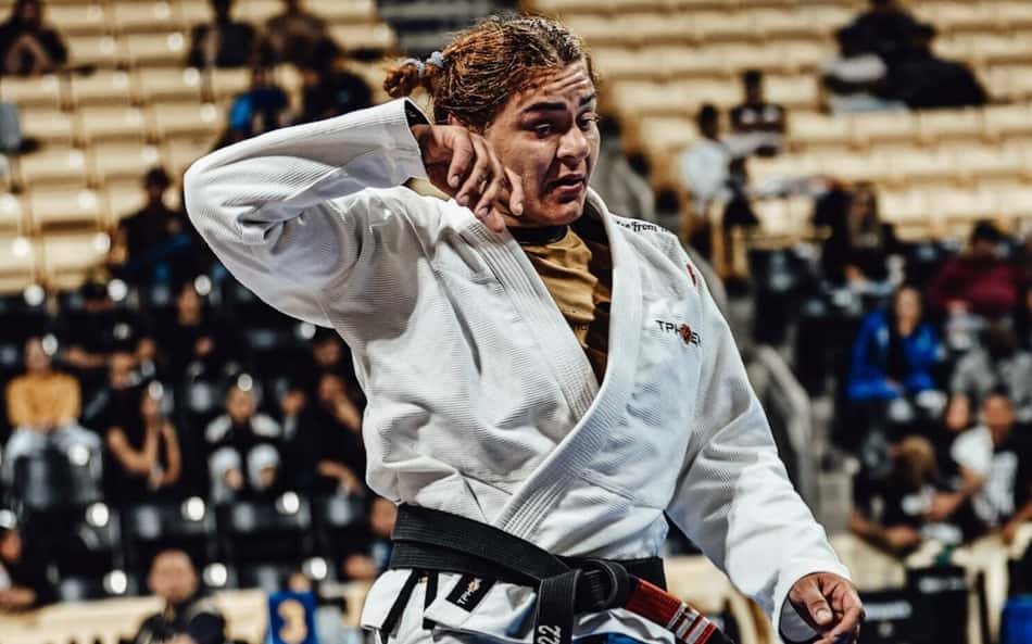Tayane Porfírio leva a mão direita ao rosto enquanto anda pelo tatame durante o Campeonato Mundial de Jiu-Jítsu