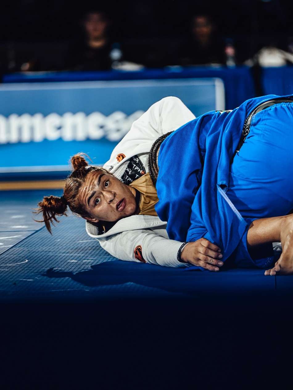 Tayane Porfírio olha para frente enquanto imobiliza atleta durante o Campeonato Mundial de Jiu-Jítsu