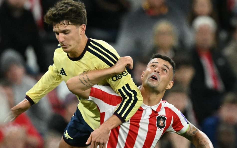 O atacante grego do Arsenal, nº 17, Christos Tzolis (E), salta acima do meio-campista suíço do Sunderland, nº 34, Granit Xhaka, durante a partida do Campeonato Inglês entre Sunderland e Arsenal, no Estádio da Luz, em Sunderland, nordeste da Inglaterra, em 12 de setembro de 2026.