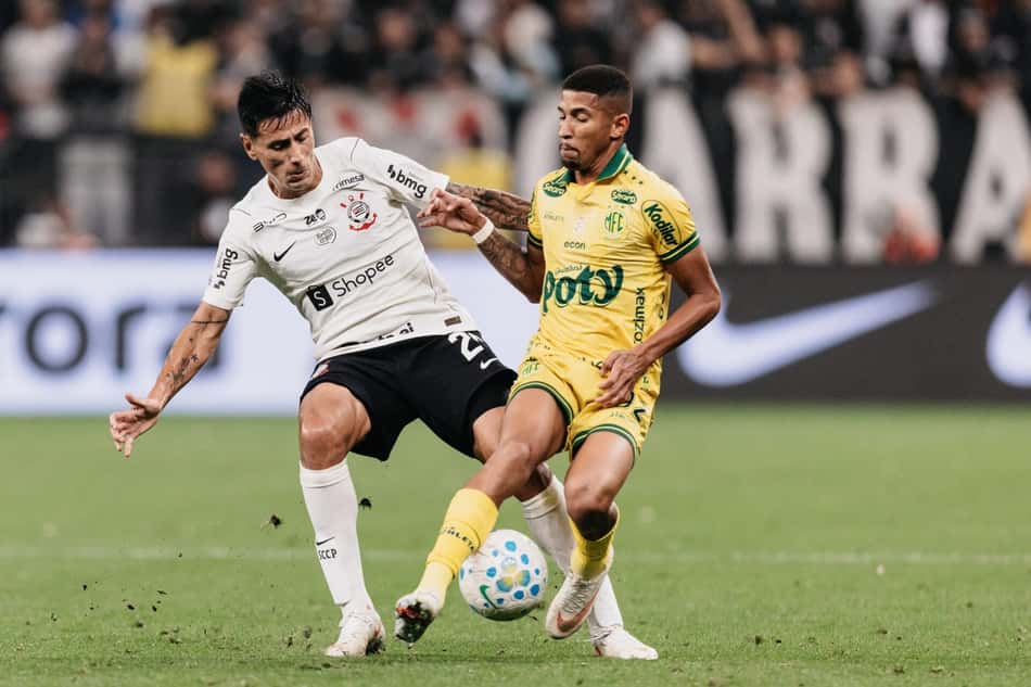 Angileri disputa a bola com adversário de uniforme amarelo em campo durante partida de futebol.