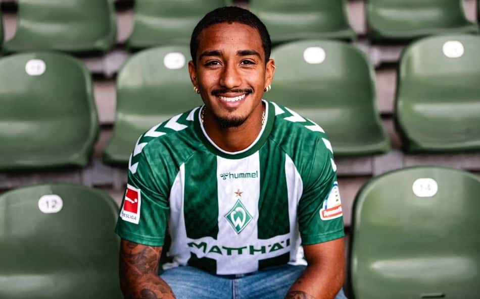 Arthur sentado na arquibancada com a camisa do Werder Bremen