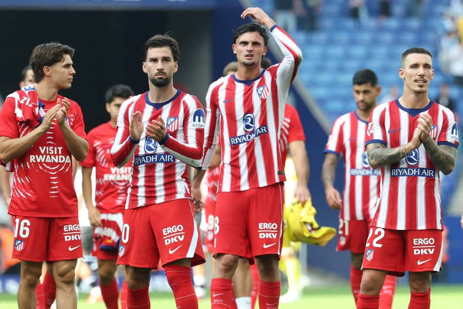 Jogadores do Atlético de Madrid em uniforme listrado vermelho e branco aplaudem em campo.
