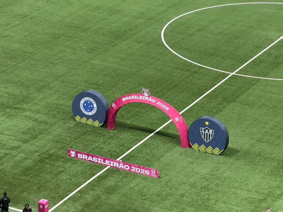 Brasileirão 2026 na Arena MRV, Atlético Mineiro x Cruzeiro, arco rosa e logotipos das equipes no gramado. Lance!)