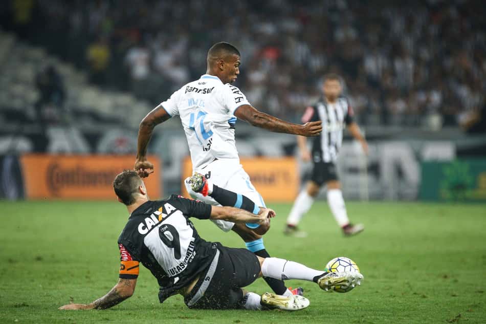 Atlético Mineiro x Grêmio, 2016: jogador de camisa branca salta enquanto adversário de preto faz carrinho pela bola.Atlético x gremio 2016 (Foto: Bruno Cantini / Atlético)