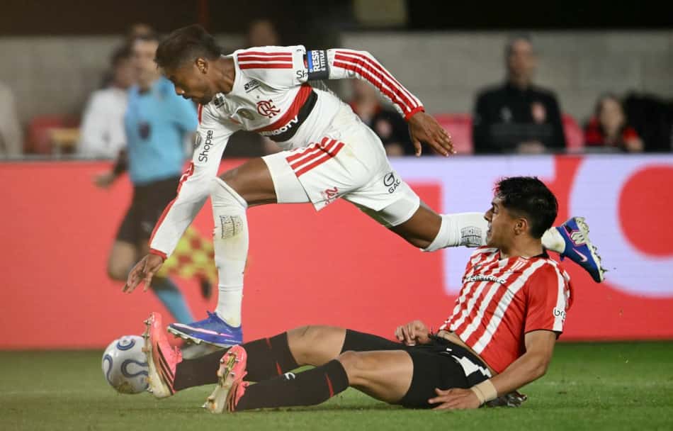 Bruno Henrique disputa a bola com um rival do Estudiantes no empate do Flamengo